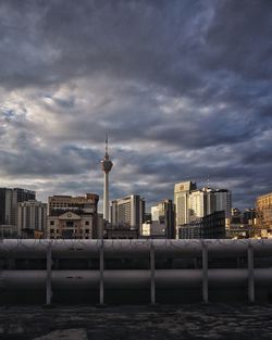 Buildings in city against cloudy sky