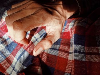 Close-up of man hand on bed