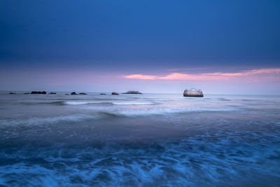 Boats in calm sea at sunset