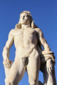 Low angle view of statue against blue sky