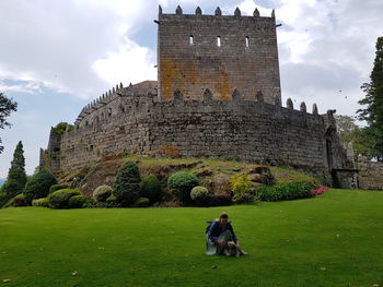 Woman in front of historic building against sky