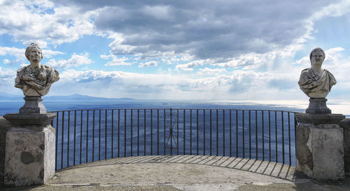 Statue by sea against sky