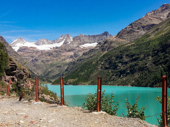 Scenic view of lake and mountains against blue sky