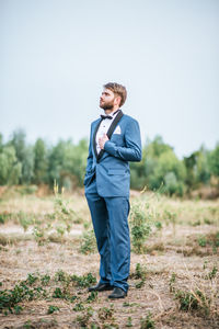 Young bridegroom standing on field