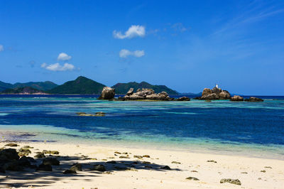 Scenic view of beach against blue sky