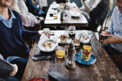 Mature man using mobile phone while having brunch with family at table