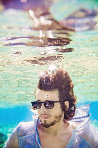  guy with the sunglasses and the shirt under the water in the ocean