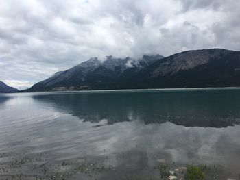 Scenic view of lake and mountains against cloudy sky