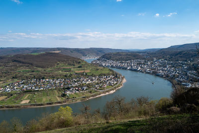 Aerial view of townscape by river against sky