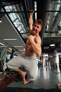 Shirtless man exercising in gym