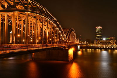 Illuminated bridge over river at night