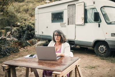 Woman using laptop while sitting at table