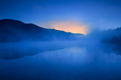 Steam emitting from hot spring at dusk