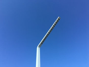 Low angle view of crane against clear blue sky