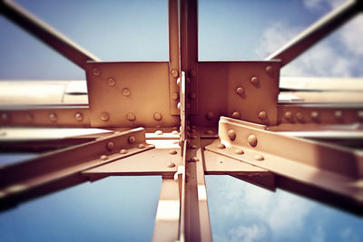 Low angle view of metal structure against blue sky