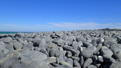 Rocks on shore against cloudy sky