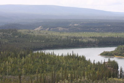 Scenic view of lake by mountains against sky