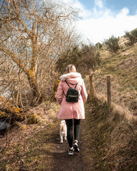 Rear view of woman walking on field
