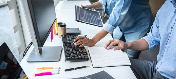 Midsection of man using laptop on table