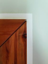 Close-up of wooden table against wall at home