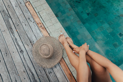 Low section of woman sitting on poolside