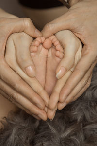 Close-up of woman holding baby hand