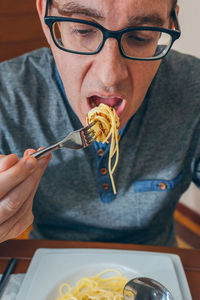 Man eating noodles and worms in restaurant