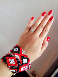 High angle view of hand with red nail polish