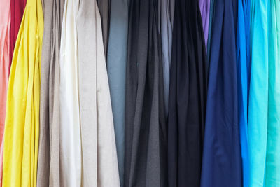 Close up view on samples of cloth and fabrics in different colors found at a fabrics market.