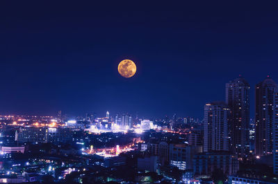 Illuminated cityscape against clear sky at night