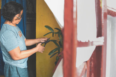 Midsection of woman standing against wall