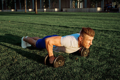 Full length of man exercising on field