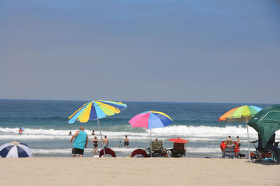 People at beach against sky