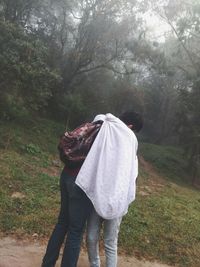 Rear view of people walking in forest