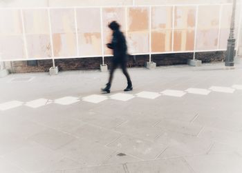 Blurred motion of person walking on road