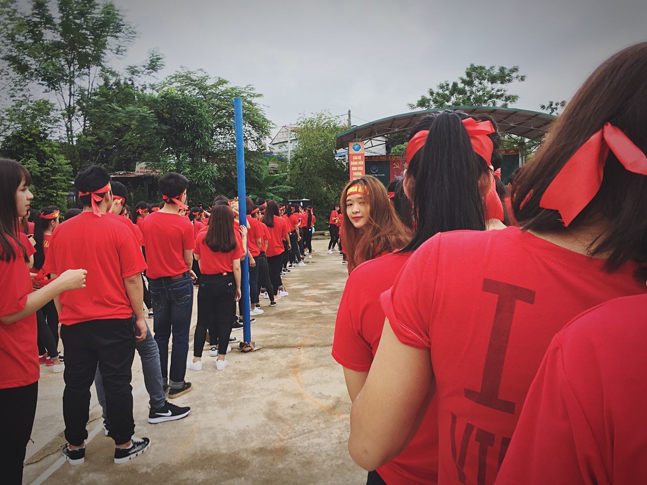 real people, tree, day, large group of people, leisure activity, men, red, outdoors, lifestyles, standing, women, sky, young adult, people