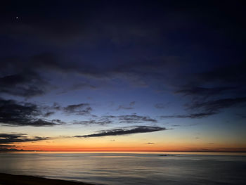 Scenic view of sea against dramatic sky during sunset