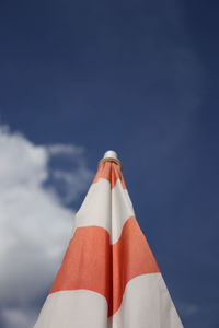 Low section of beach umbrella against blue sky