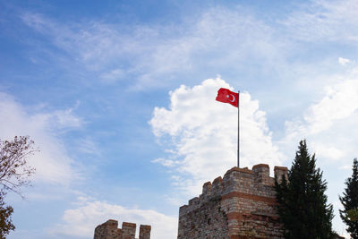 Low angle view of flag on building against sky