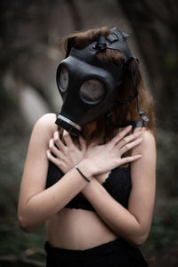 Woman wearing gas mask while covering chest