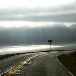 Empty road against cloudy sky