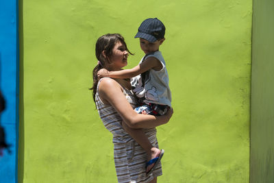 Side view of woman standing against wall