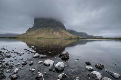 Scenic view of lake by mountain against sky