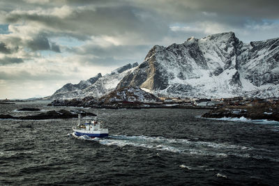 Scenic view of sea and snowcapped mountain against sky