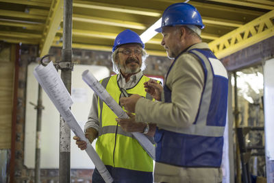 Construction worker and engineer discussing project in site office