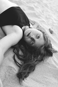 High angle portrait of girl lying on sand