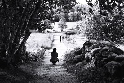 Rear view of man and woman standing by trees