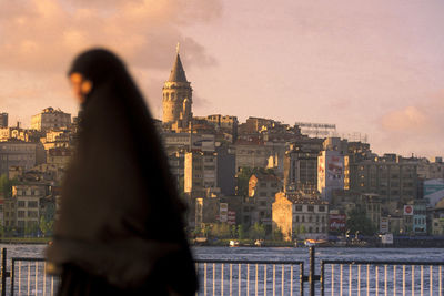 Man looking at city buildings against sky