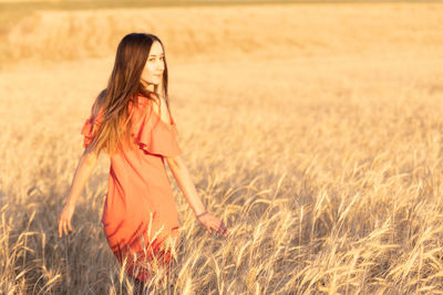 Young woman in the wheat field. look back. finding inner balance concept. copy space