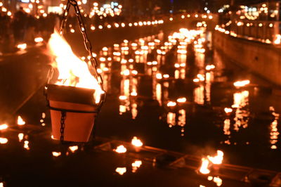 Close-up of lit candles burning at night